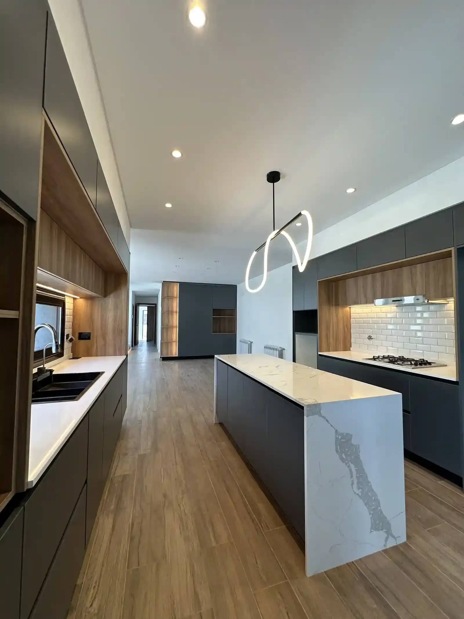 Cocina integrada de Casa Adrogué abierta hacia la galería y la pileta