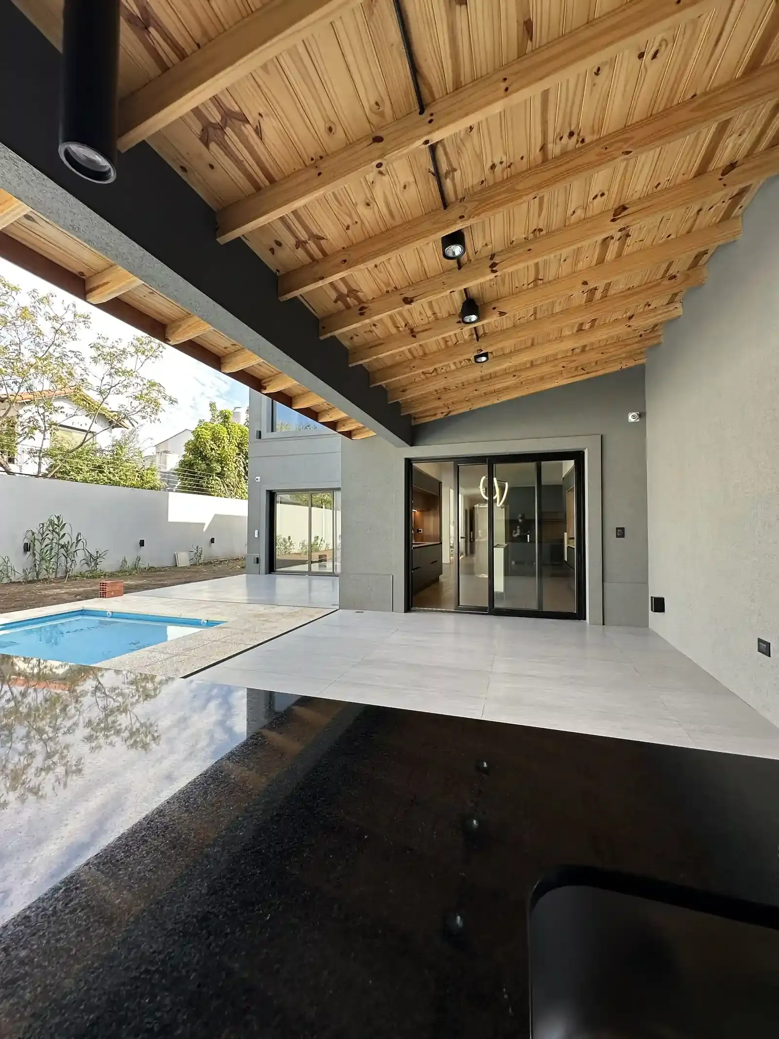Galería de Casa Adrogué con techo de madera a la vista y visual a la pileta