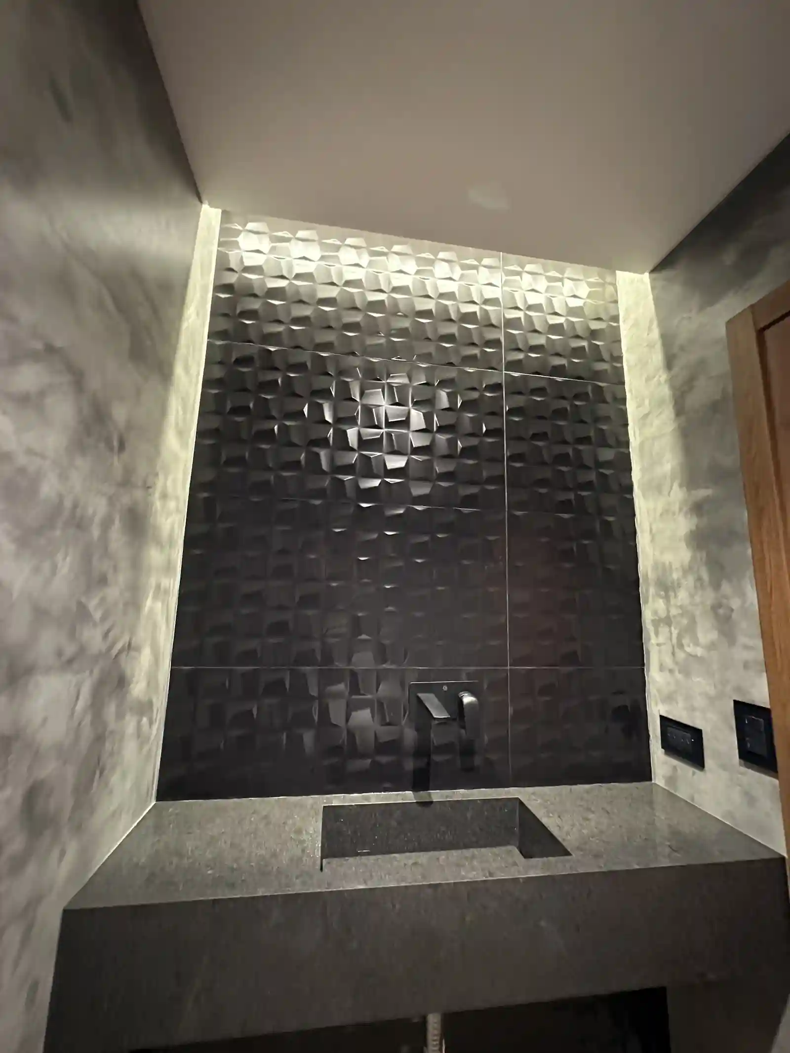 Cerámica negra tridimensional retroiluminada en el toilette de Casa Adrogué