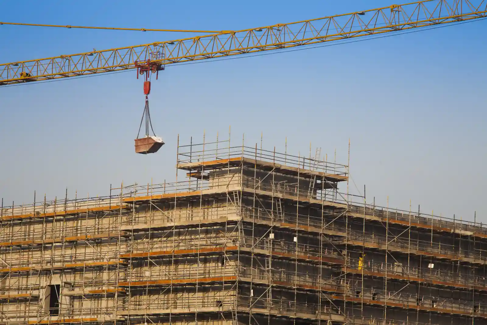 Edificio en construcción con grúa: ejecución de obra de una constructora
