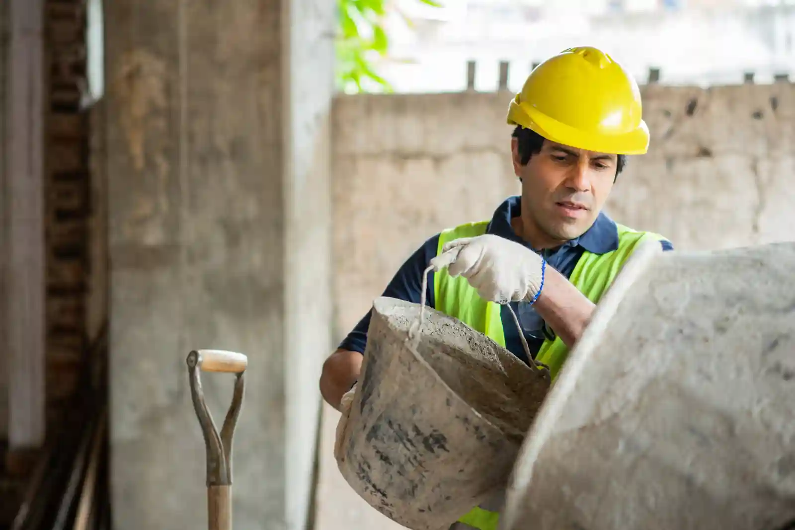 Albañil trabajando en obra levantando una pared de ladrillos